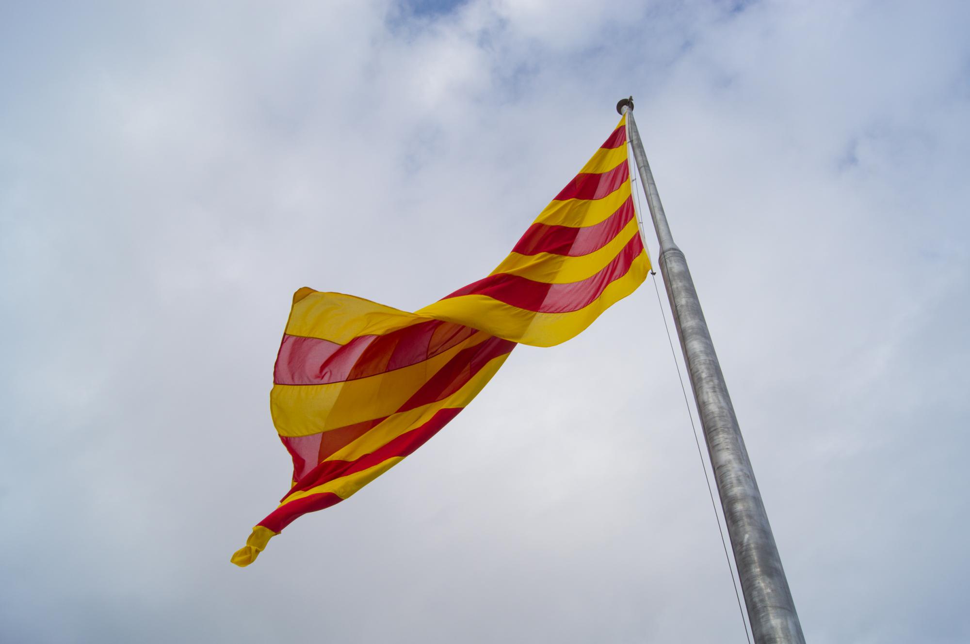 Флаг Каталонии развевается над замком на горе Монжуик в Барселоне