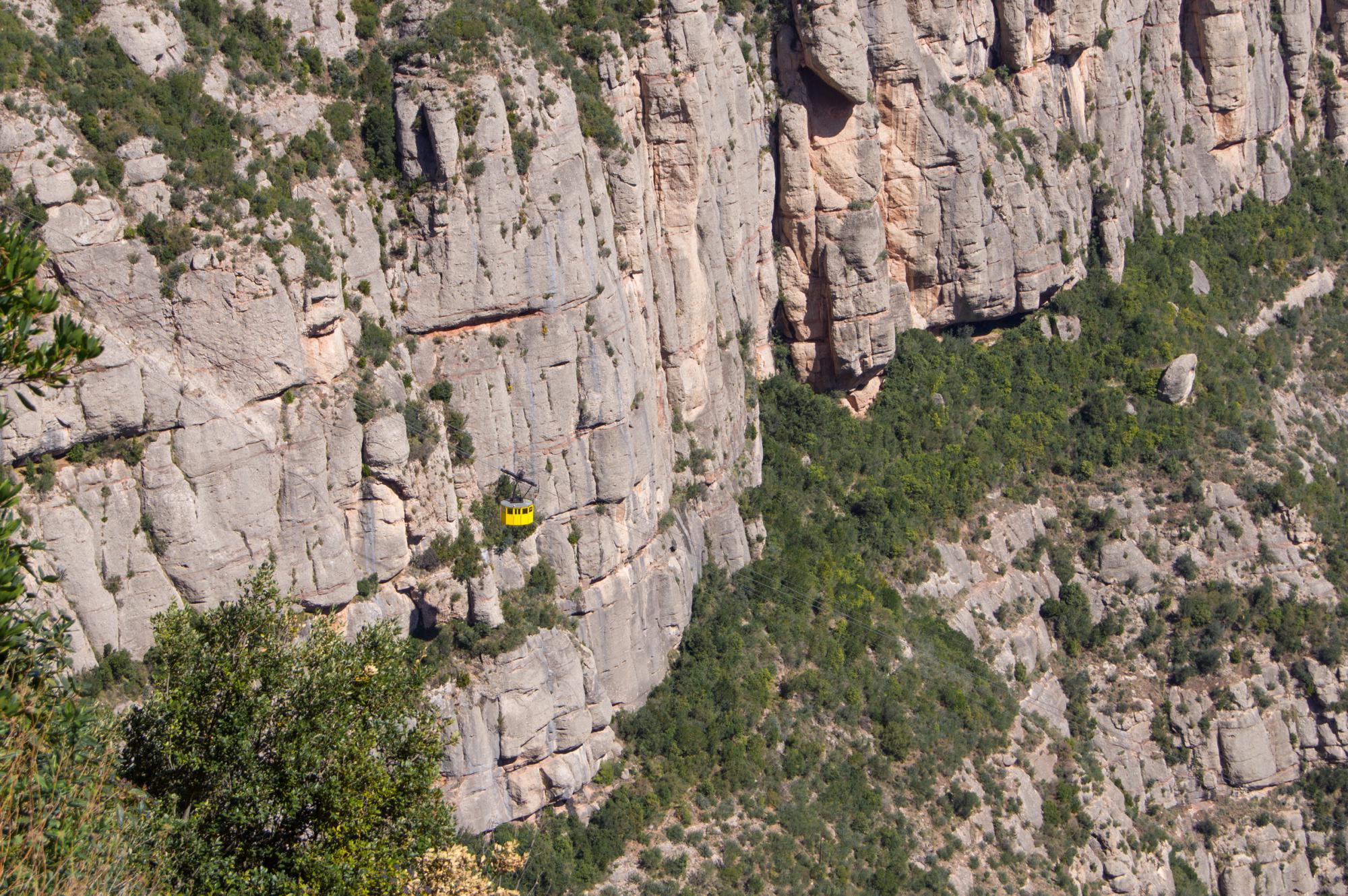 Yellow cabin of Aeri de Montserrat on the background of rocks