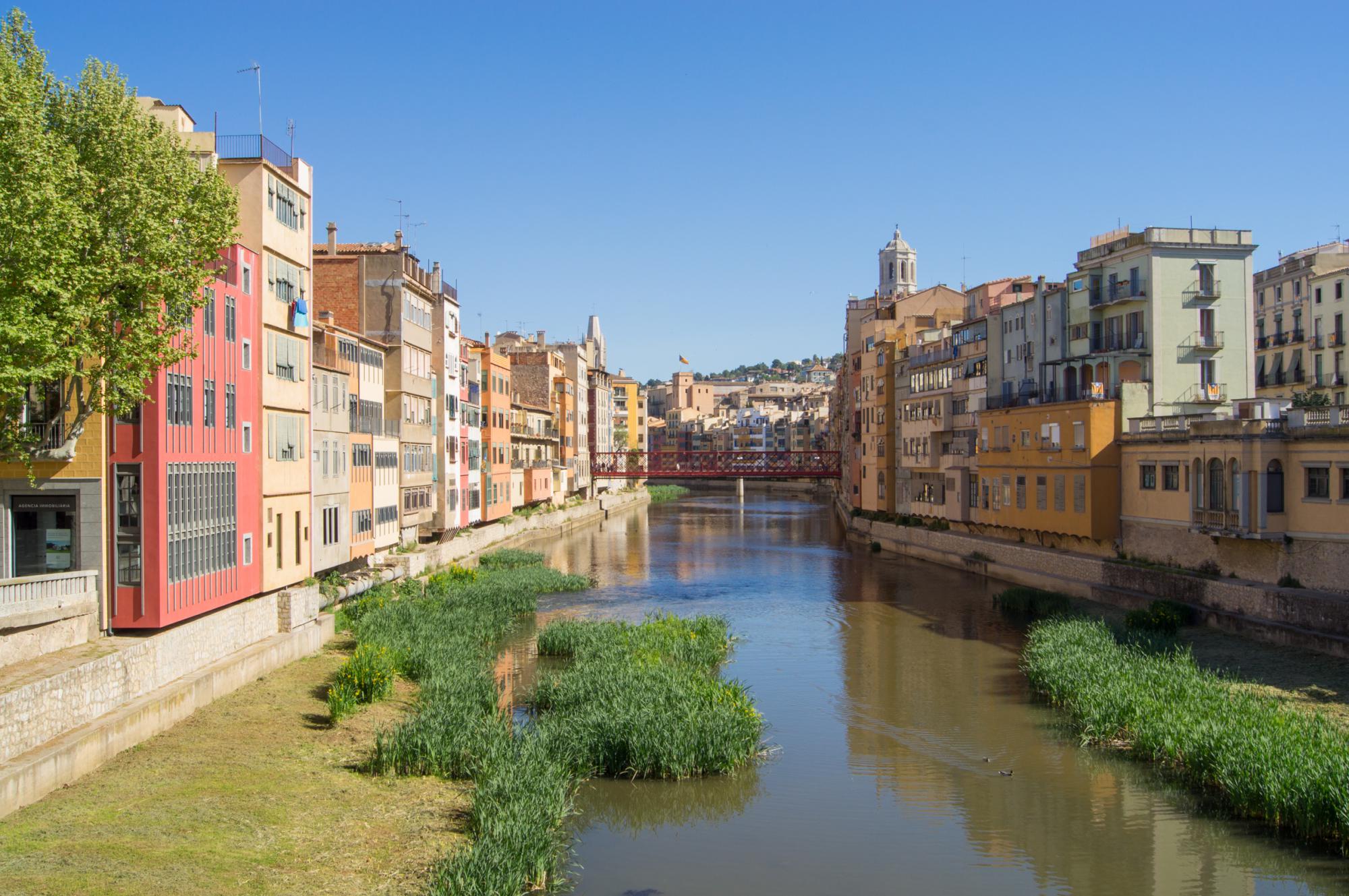 Red metal Eiffel's bridge over the river Onyar in Girona